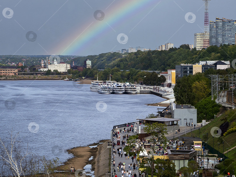 Скачать Летний городской пейзаж. Набережная реки Камы. Комфортабельные теплоходы стоят у пристани, люди гуляют по набережной. На горе видны жилые дома. В небе раскинулась большая радуга. фотосток Ozero