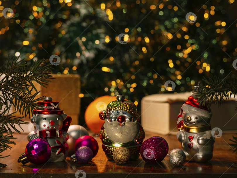 Скачать концепция Рождества и Нового года. Рождественские игрушки (снеговик, Дед Мороз) на фоне подарков под рождественской елкой. праздничный фон зимнего праздника.  Открытка, место для копирования фотосток Ozero