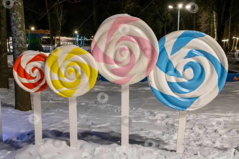 Скачать В парке есть красочные украшения из конфет, разноцветный спиральный леденец на палочке.Зимний парк фотосток Ozero
