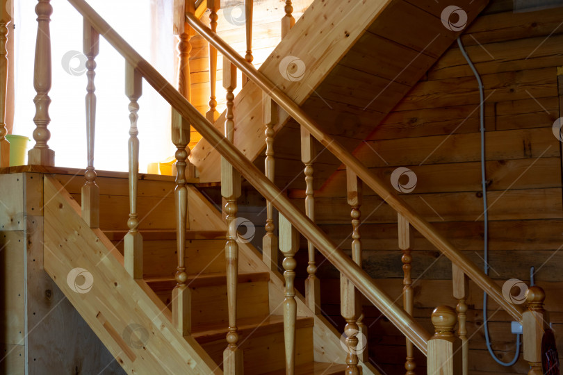Скачать Деревянная лестница, окрашенная светлым лаком, ведет на второй этаж в деревенском доме фотосток Ozero