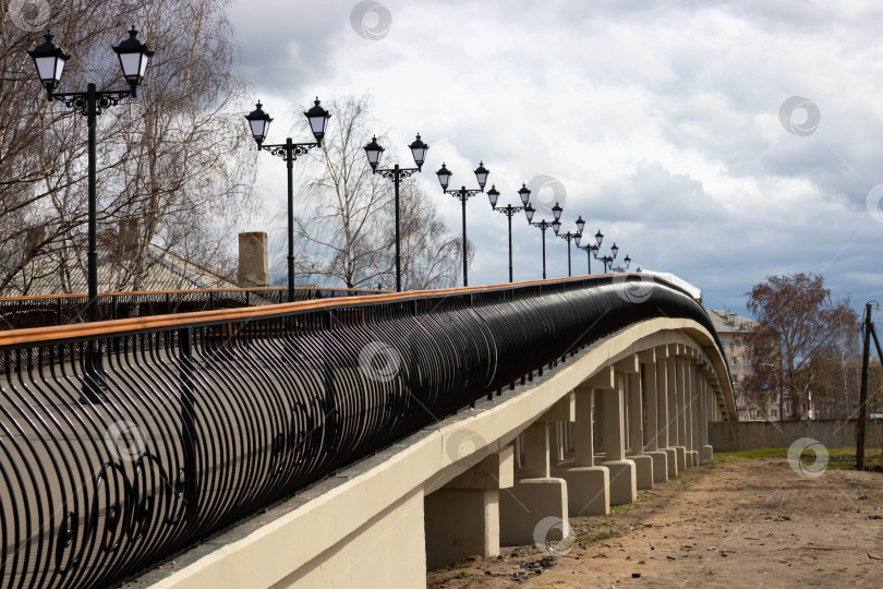 Скачать Перила, металлическая конструкция и фонари моста на фоне облачного неба. Абстрактная фотография моста фотосток Ozero