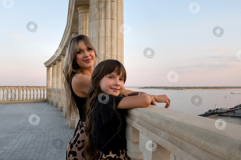 Скачать Мама и маленькая дочка гуляют по вечернему городу фотосток Ozero