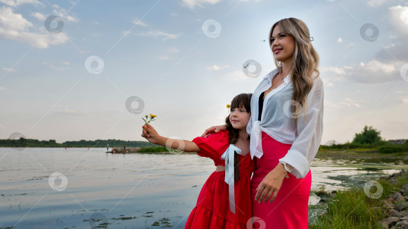 Скачать Мама и маленькая дочка гуляют у озера или пруда фотосток Ozero