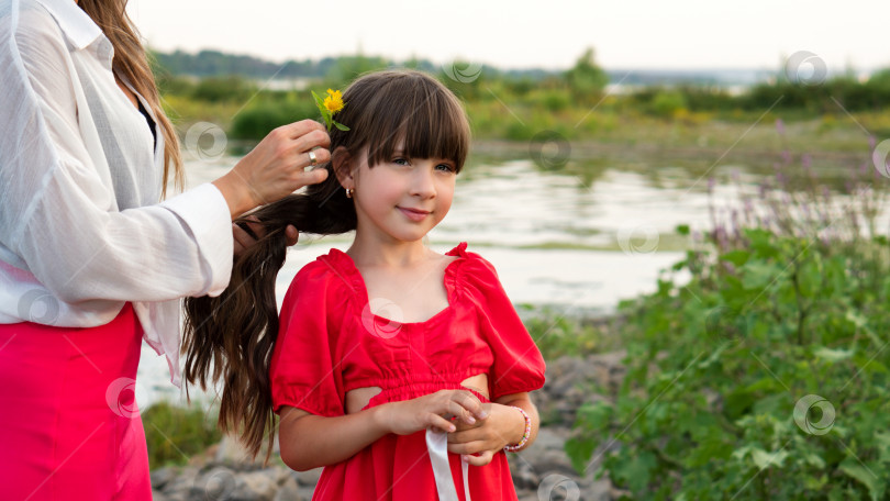 Скачать Мама вплетает живые цветы в косу дочери фотосток Ozero