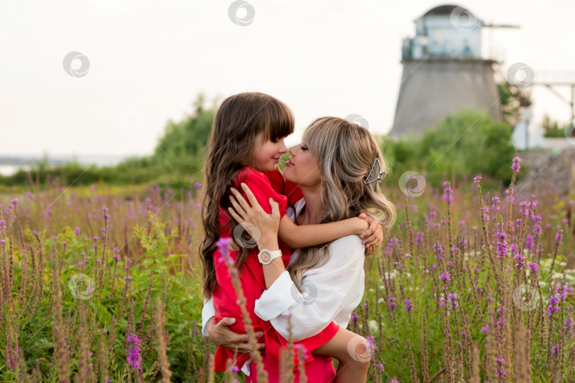 Скачать Мама и маленькая дочка прогуливаются среди луговых цветов фотосток Ozero