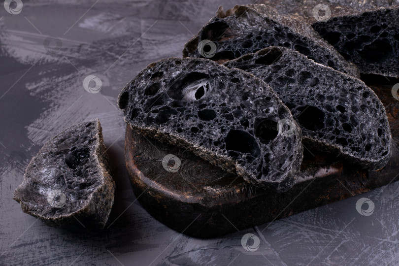 Скачать Черный хлеб чиабатта, нарезанный ломтиками на древесном угле фотосток Ozero