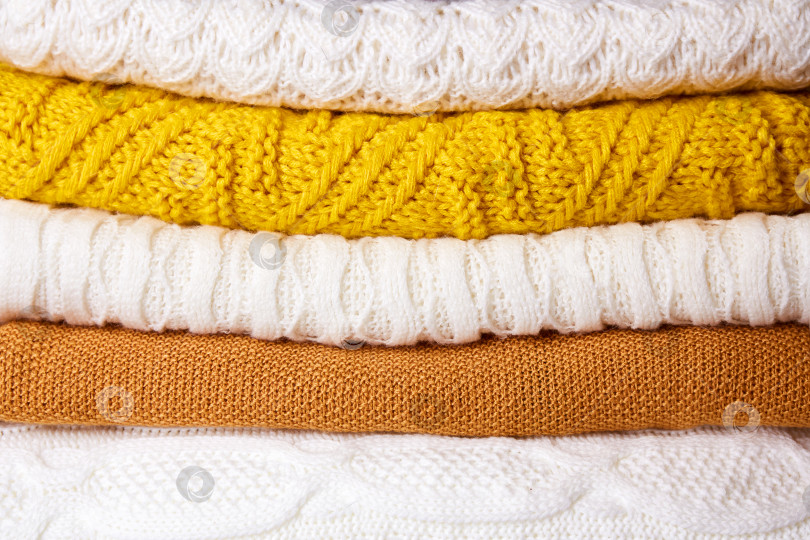 Скачать Стопка сложенных вязаных свитеров. Осенняя и зимняя шерстяная одежда фотосток Ozero