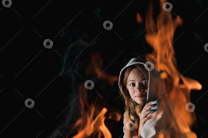 Скачать Взгляд молодой девушки сквозь огонь в полной темноте фотосток Ozero