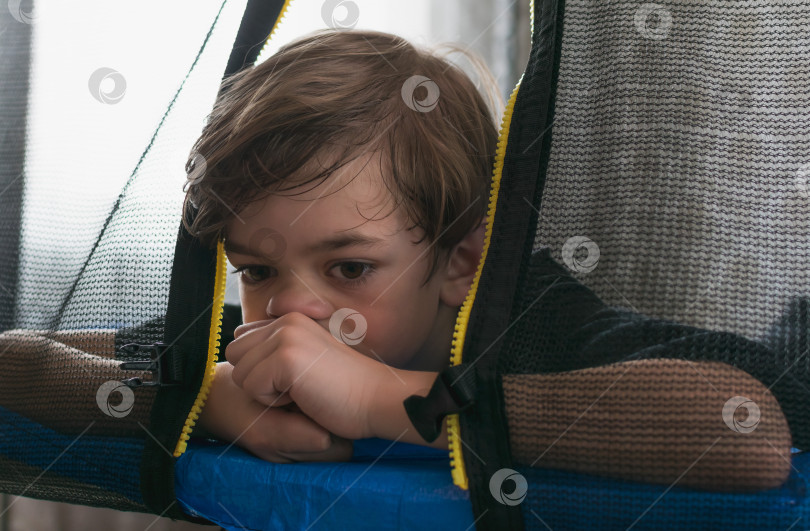 Скачать Маленький мальчик играет на круглом батуте фотосток Ozero