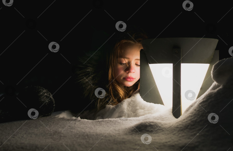 Скачать Молодая девушка играет ночью в снегу фотосток Ozero