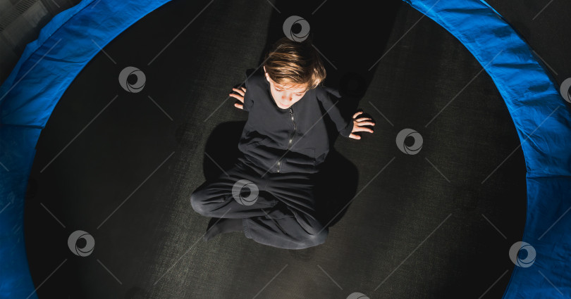 Скачать Маленький мальчик играет на круглом батуте фотосток Ozero
