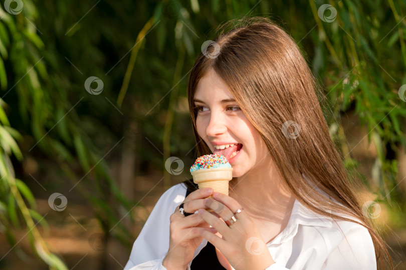 Скачать Девочка-подросток ест мороженое на прогулке фотосток Ozero
