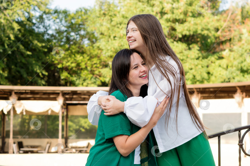 Скачать Мама и дочь-подросток обнимаются на прогулке в парке фотосток Ozero