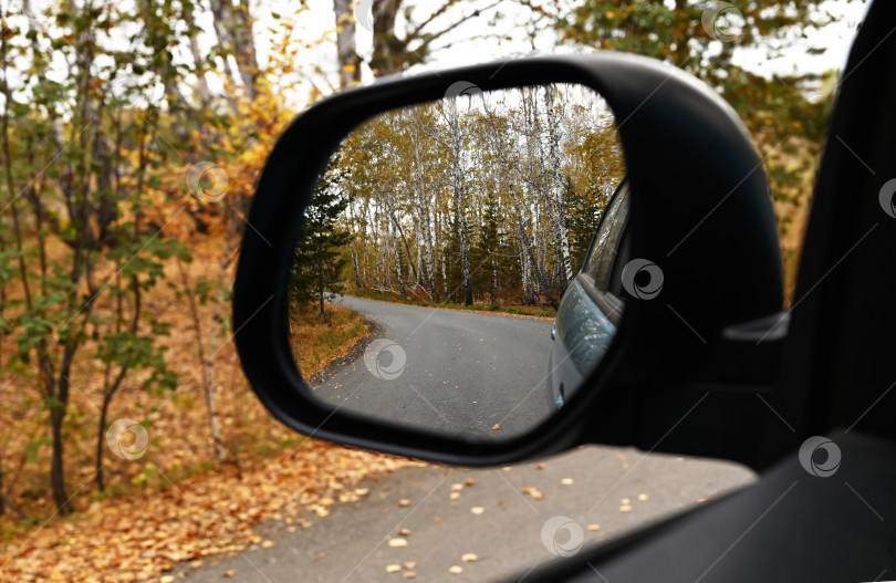 Скачать Вид на осеннюю дорогу через зеркало заднего вида автомобиля фотосток Ozero