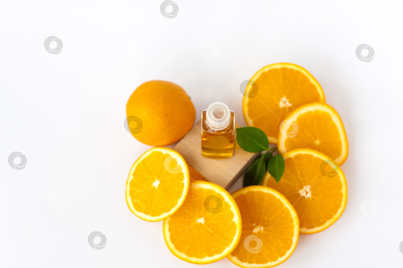 Скачать Апельсиновое масло для тела. Нарезанный апельсин на белом фоне. Органическая СПА-косметика с растительными ингредиентами. фотосток Ozero
