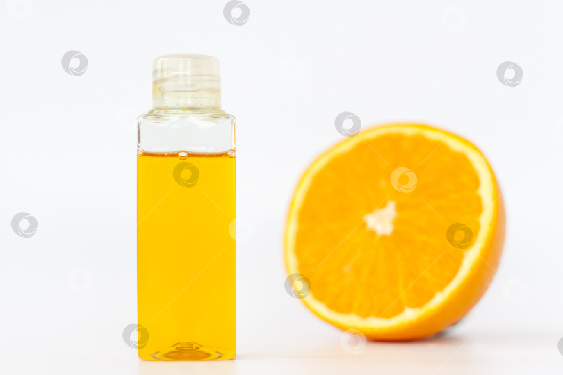 Скачать Апельсиновое масло для тела. Нарежьте апельсин на белом фоне. Органическая СПА-косметика с растительными ингредиентами. фотосток Ozero