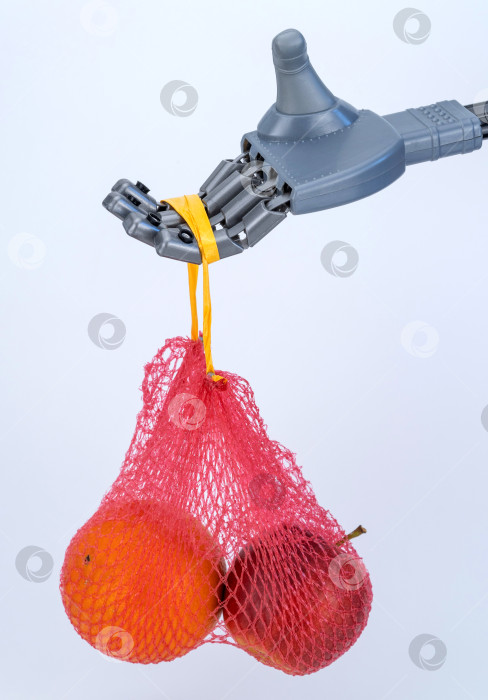 Скачать рука робота держит сетку с фруктами. доставка еды с использованием технологий и искусственного интеллекта фотосток Ozero