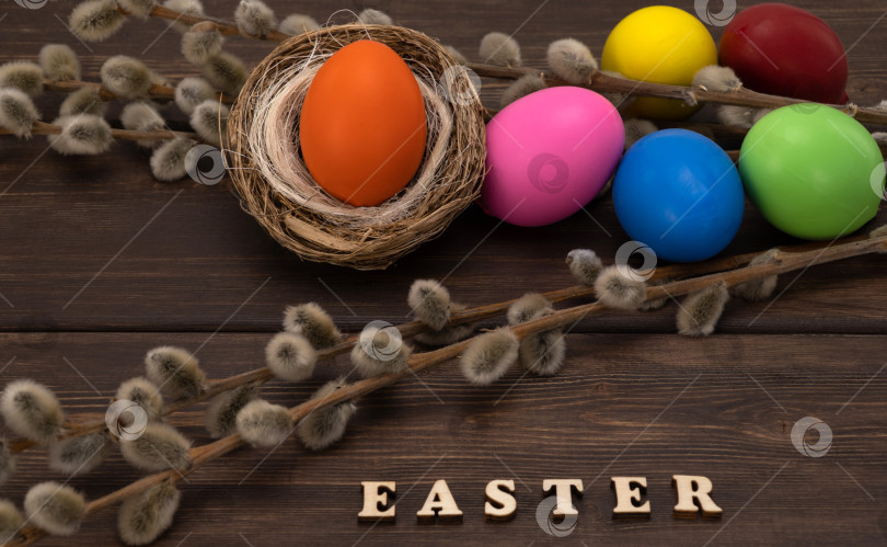 Скачать разноцветные пасхальные яйца с веткой ивы на старинных досках. пасхальная надпись на деревянном фоне. фотосток Ozero