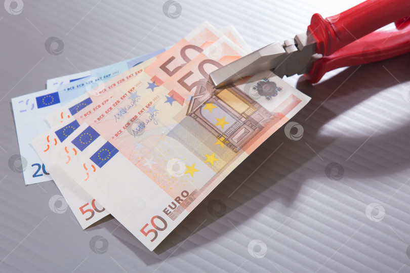 Скачать банкноты евро, зажатые плоскогубцами фотосток Ozero