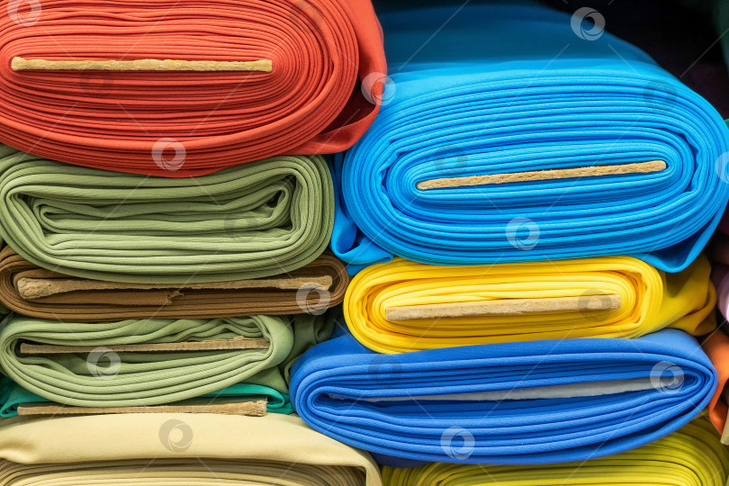 Скачать Рулоны яркой разноцветной ткани на полке в магазине. Продажа модных тканей для одежды. фотосток Ozero