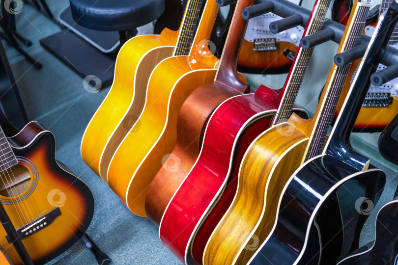 Скачать Деревянные классические гитары в селективном фокусе с эффектом затухания. Продажа струнных инструментов в музыкальном магазине. фотосток Ozero