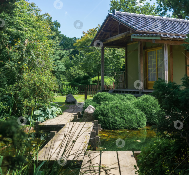 Скачать японский сад с зигзагообразным мостиком через пруд и чайным домиком фотосток Ozero