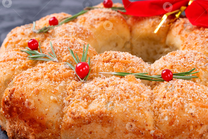 Скачать Рождественский венок из хлеба с сыром, посыпанный розмарином и красными ягодами. фотосток Ozero