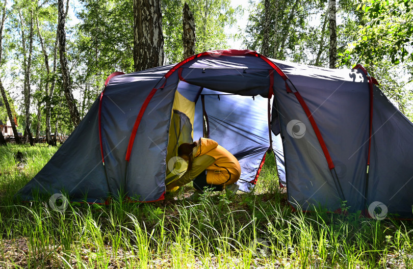 Скачать Девушка устанавливает походную палатку во время своего пребывания на природе фотосток Ozero