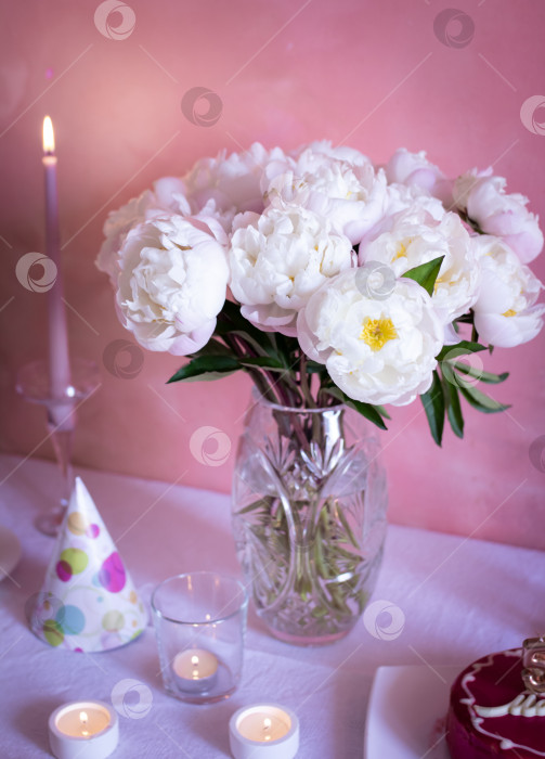 Скачать Белые пионы в стеклянной вазе на фоне розовой стены, цветы для сервировки стола, выборочный акцент фотосток Ozero