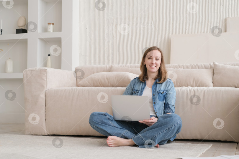 Скачать Милая красивая дама работает за ноутбуком, сидя дома на диване. концепция технологичной женщины для альтернативного офисного фрилансера. Удаленный домашний офис фотосток Ozero