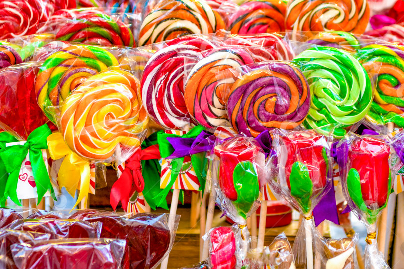 Скачать В магазине продаются вкусные разноцветные леденцы на палочке, леденцовые конфеты. Приятный фон. фотосток Ozero