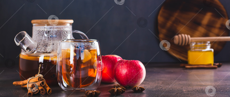 Скачать Горячий чай с яблоками, корицей, бадьяном и медом в чашке и чайнике на столе веб-баннер фотосток Ozero
