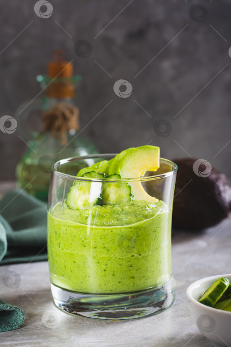 Скачать Зеленый смузи из авокадо и огурцов в бокале на столе вертикальный вид фотосток Ozero