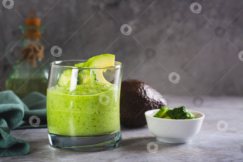 Скачать Зеленый смузи из авокадо и огурцов в бокале на столе фотосток Ozero