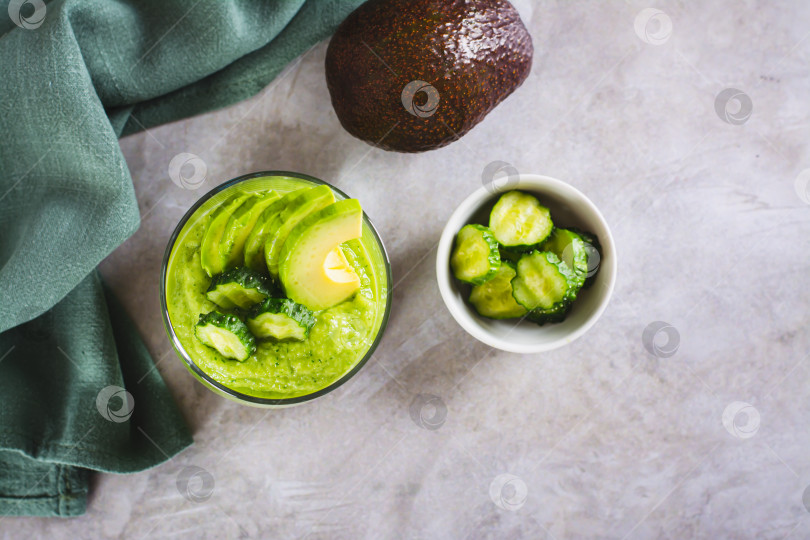 Скачать Зеленый смузи из авокадо и огурцов в бокале на столе вид сверху фотосток Ozero