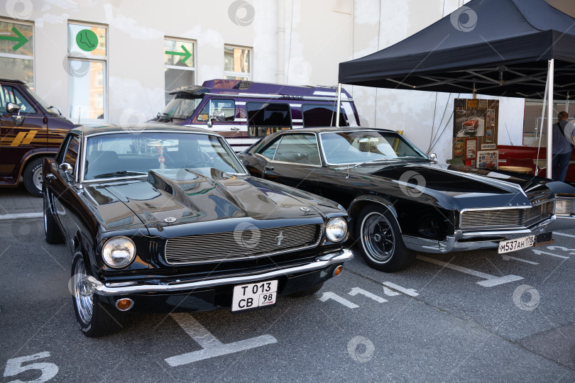 Скачать Черные Ford Mustang и Buick Riviera на выставке ретроспектива оригинальной встречи - Санктпетербург, Россия, сентябрь 2023 фотосток Ozero