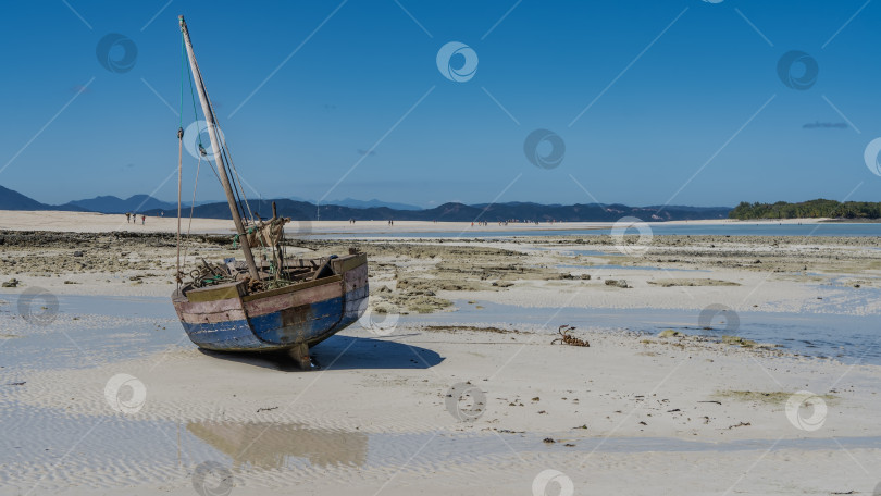 Скачать Старая самодельная деревянная лодка на мелководье во время отлива. фотосток Ozero