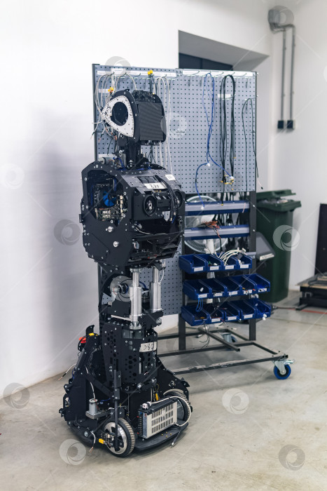 Скачать наполовину собранный человекоподобный робот в процессе сборки и наладки в мастерской фотосток Ozero