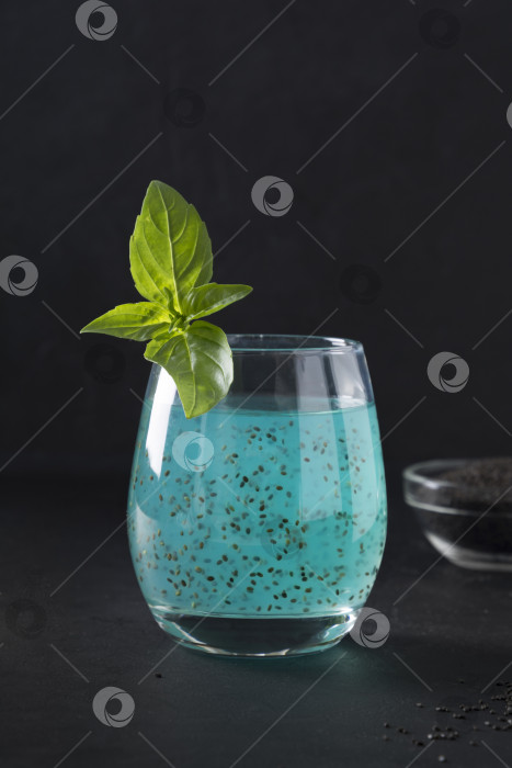 Скачать Голубой напиток из семян базилика с тропическим соком в черном бокале. Закрыть. фотосток Ozero