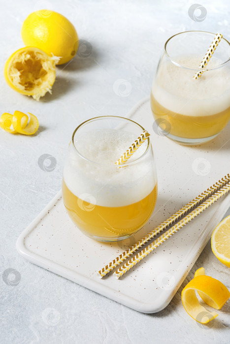 Скачать Коктейль Whiskey sour - бурбон с лимонным соком, сахарным сиропом и яичным белком в стакане. Вертикальная ориентация. фотосток Ozero