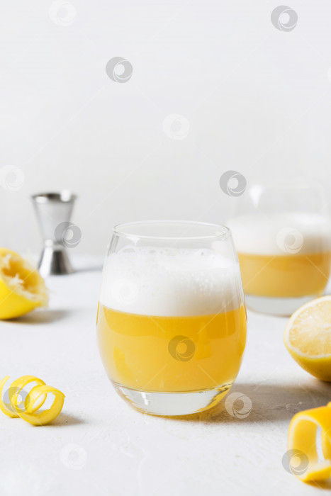 Скачать Коктейль Whiskey sour - бурбон с лимонным соком, сахарным сиропом и яичным белком в стакане. Вертикальная ориентация. фотосток Ozero