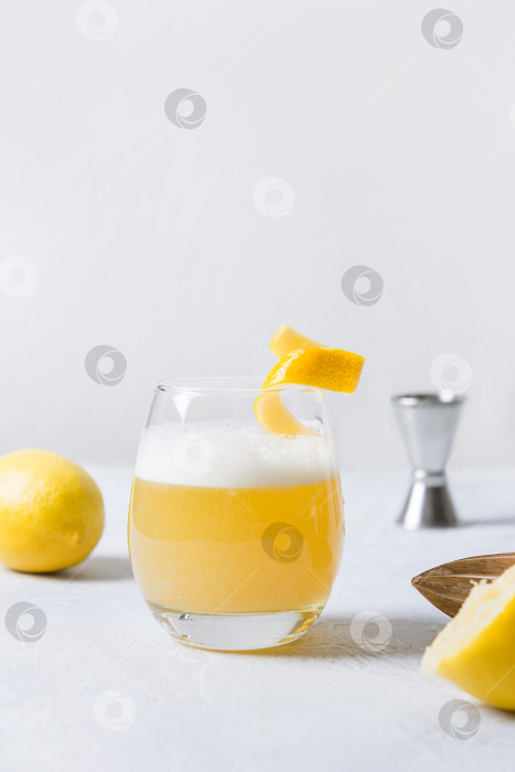 Скачать Коктейль Whiskey sour - бурбон с лимонным соком, сахарным сиропом и яичным белком в стакане. Вертикальная ориентация. фотосток Ozero