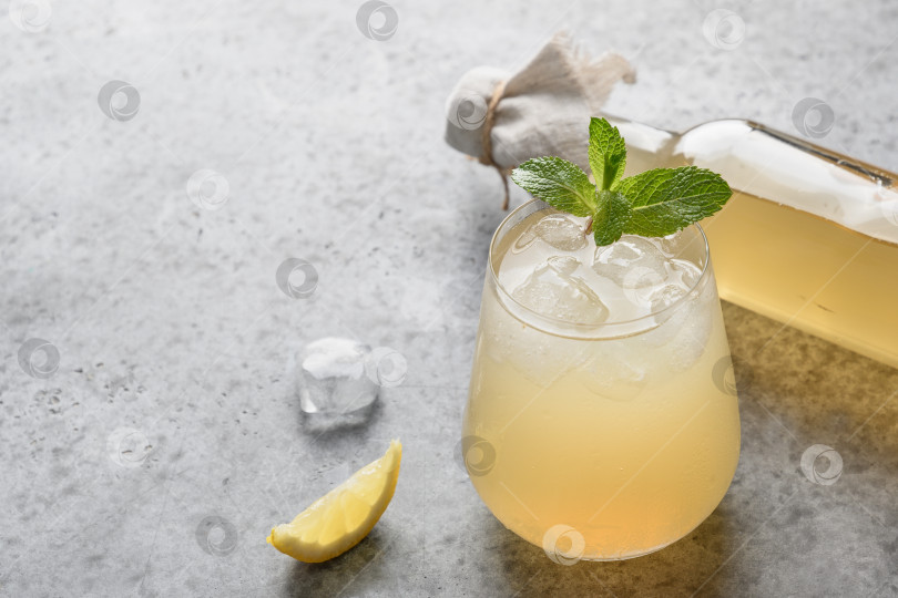 Скачать Полезный напиток из домашнего чайного гриба в бутылке и стакане с лимоном. фотосток Ozero