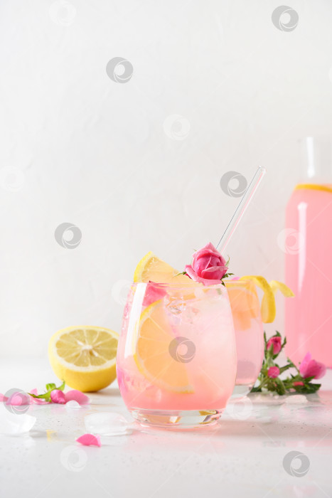 Скачать Разливка розового алкогольного коктейля с розовыми цветами на белом фоне. фотосток Ozero