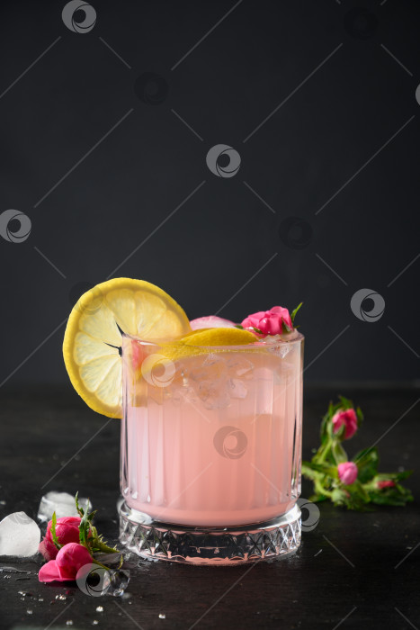 Скачать Коктейль свежести с розовым джином и лимоном на черном фоне. фотосток Ozero