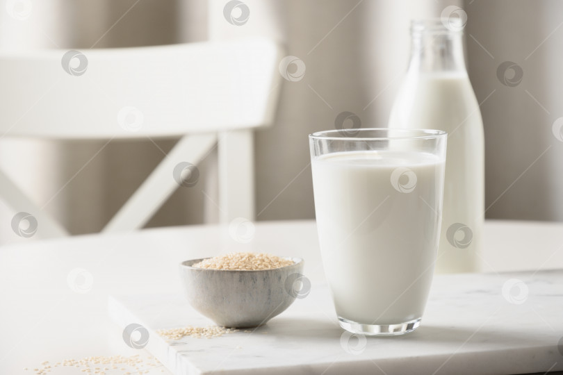 Скачать Кунжутное молоко на белом фоне кухни. Не содержит лактозы. Закрыть. Недостаток холестерина. фотосток Ozero
