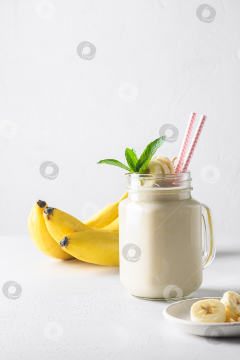 Скачать Банановый молочный коктейль на белой доске. Вертикальный формат фотосток Ozero