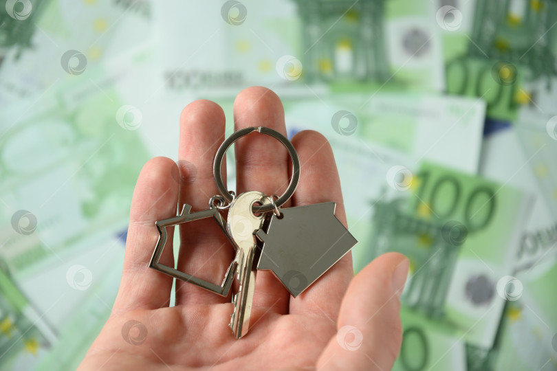 Скачать Ключи от нового дома в руках на фоне валюты евро. фотосток Ozero