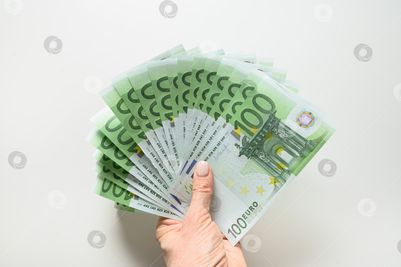 Скачать Руки держат европейские деньги в банкнотах достоинством 100 евро. Закрыть. фотосток Ozero