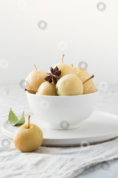 Скачать Маринованные яблоки в миске на столе из белого камня. фотосток Ozero